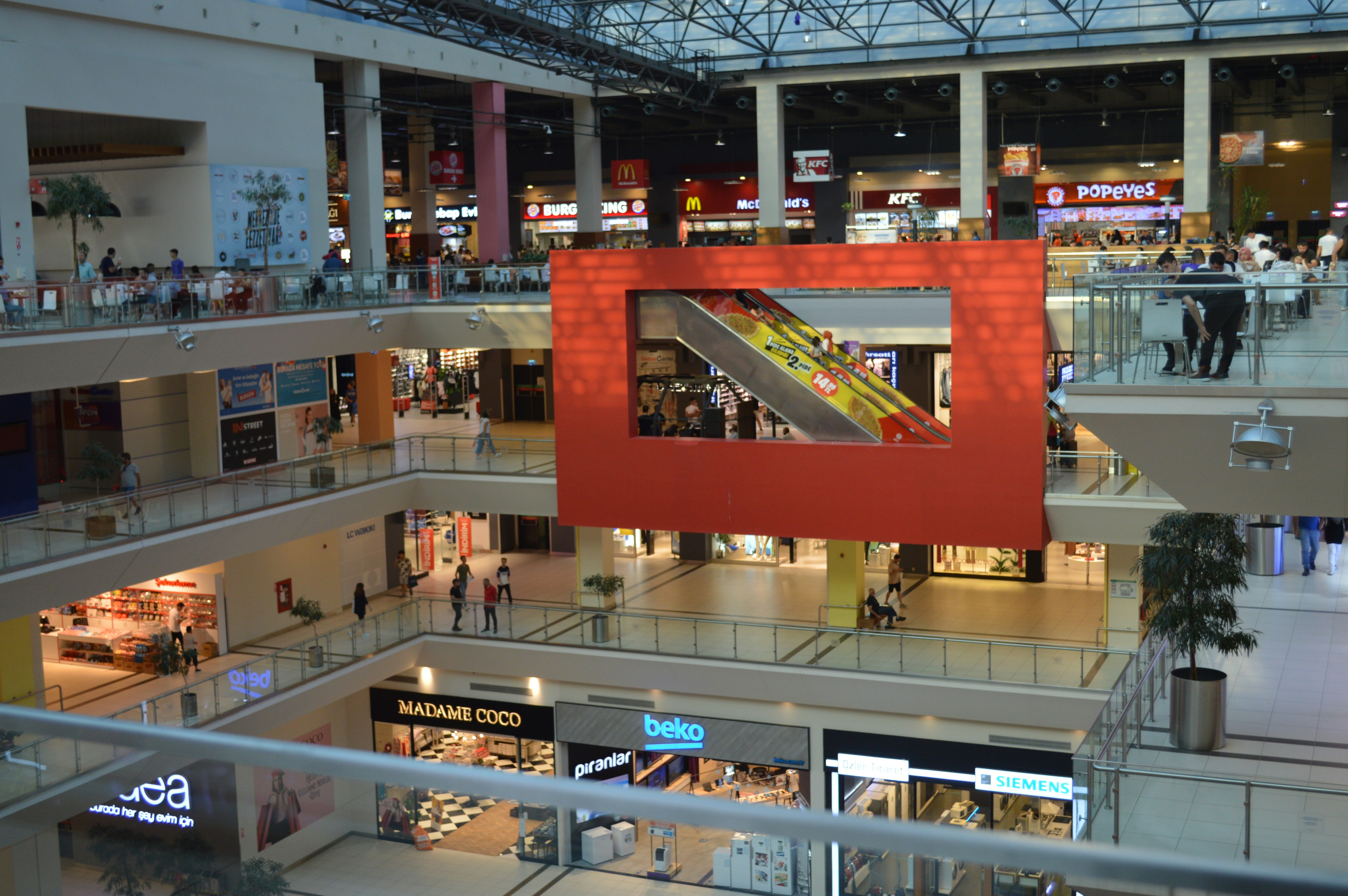 a mall with people and escalators