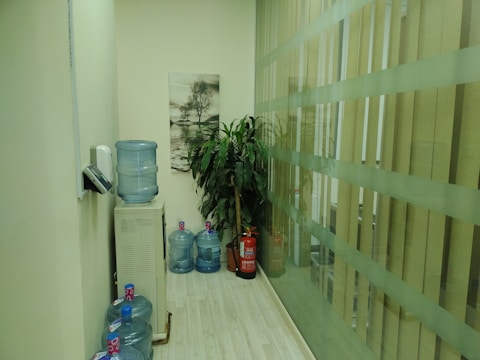 Workers installing a large water dispenser in a commercial office lobby.