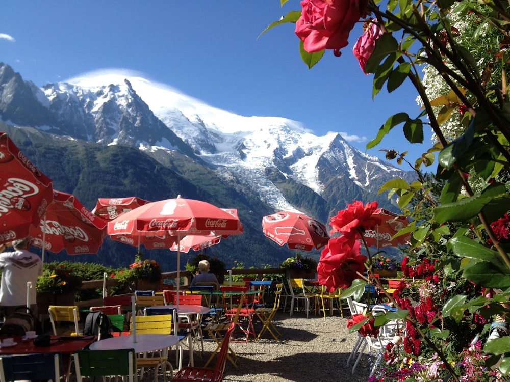 a group of tables and chairs in front of a mountain