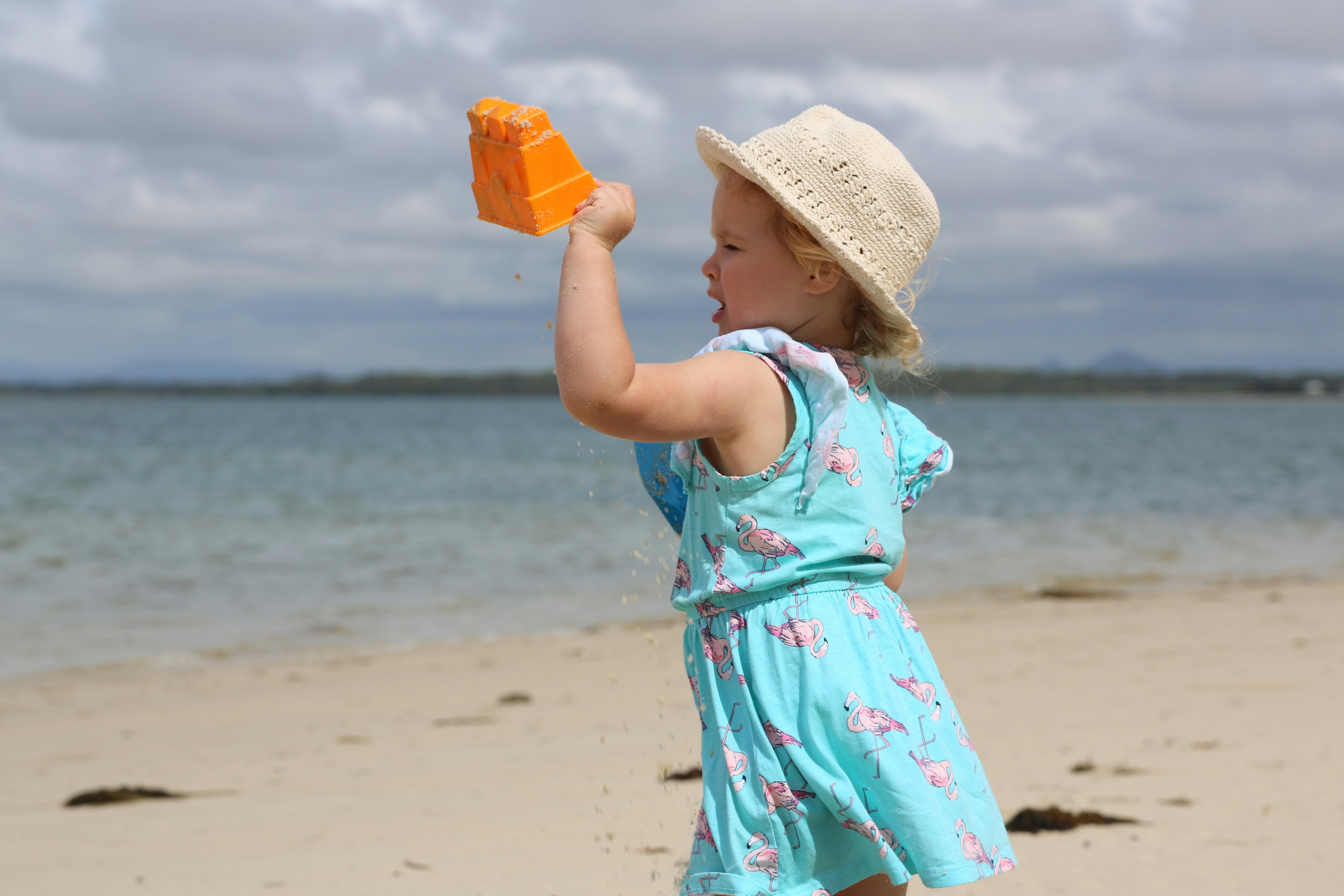 Une petite fille tenant un jouet sur une plage