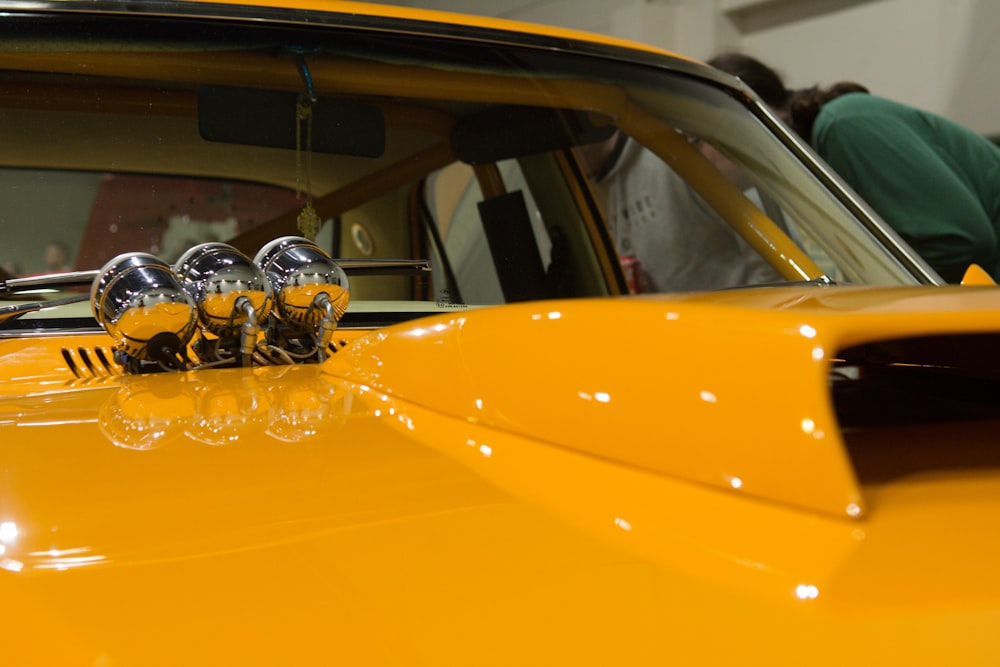 a yellow car with a person in the background