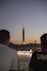 a group of people on a boat in front of a tall tower