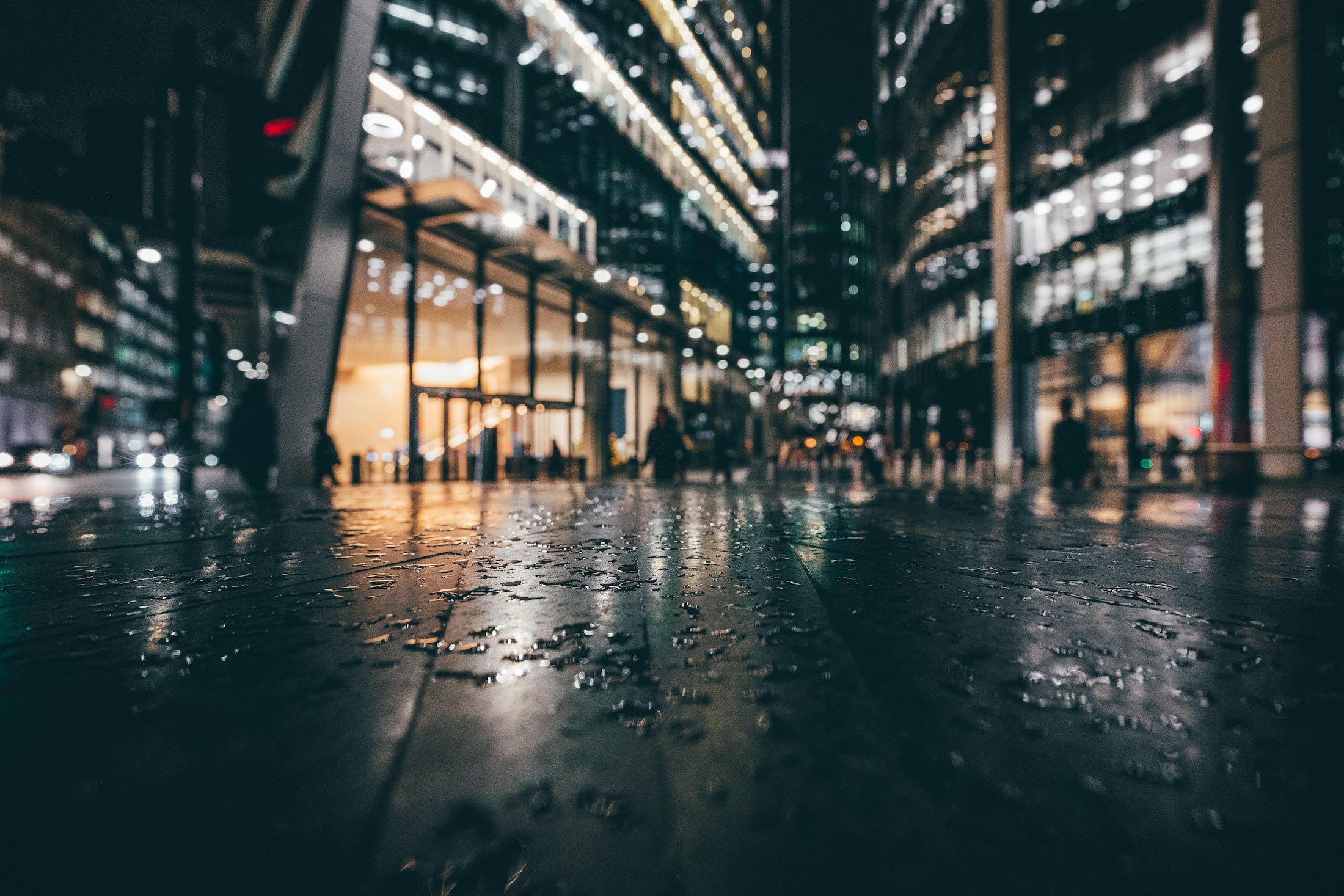 Rain-soaked city street at night reflecting streetlights, placeholder closing image