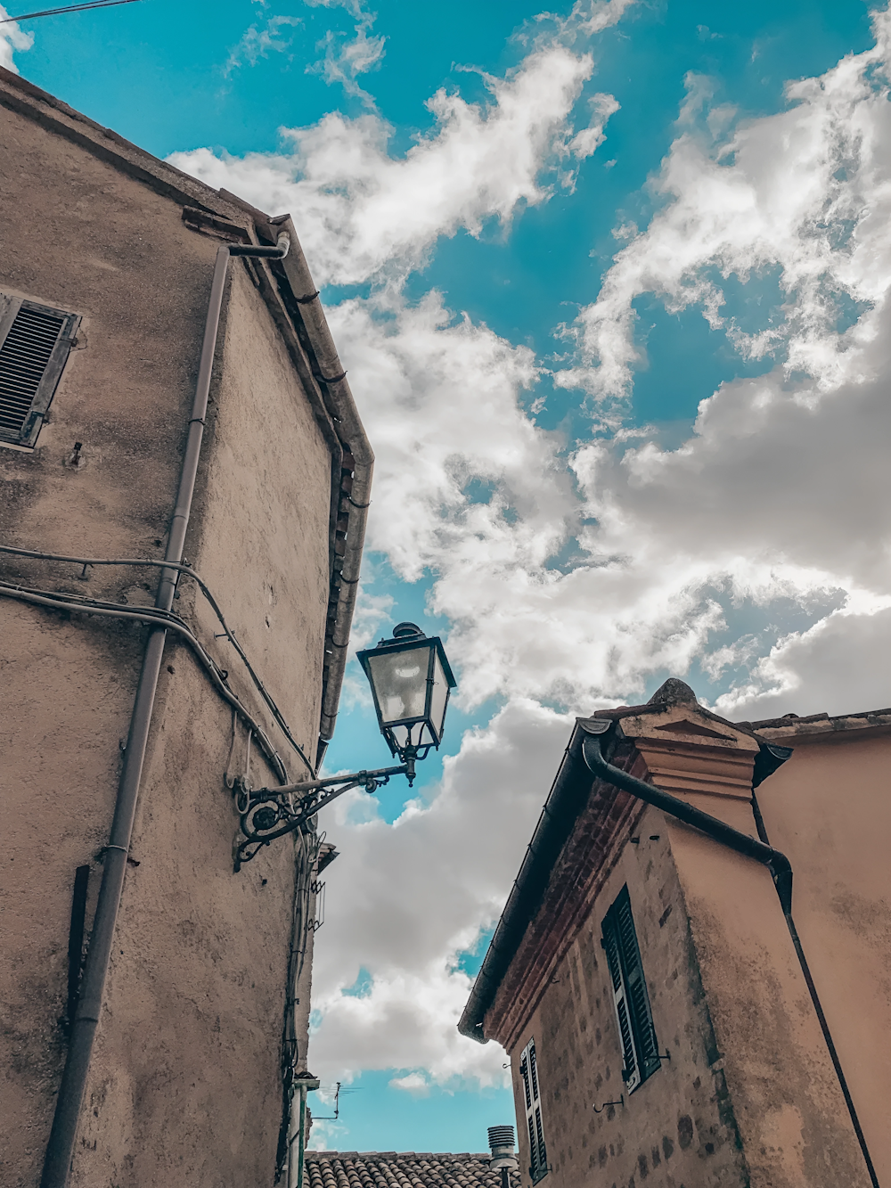 a street light and buildings under a cloudy sky