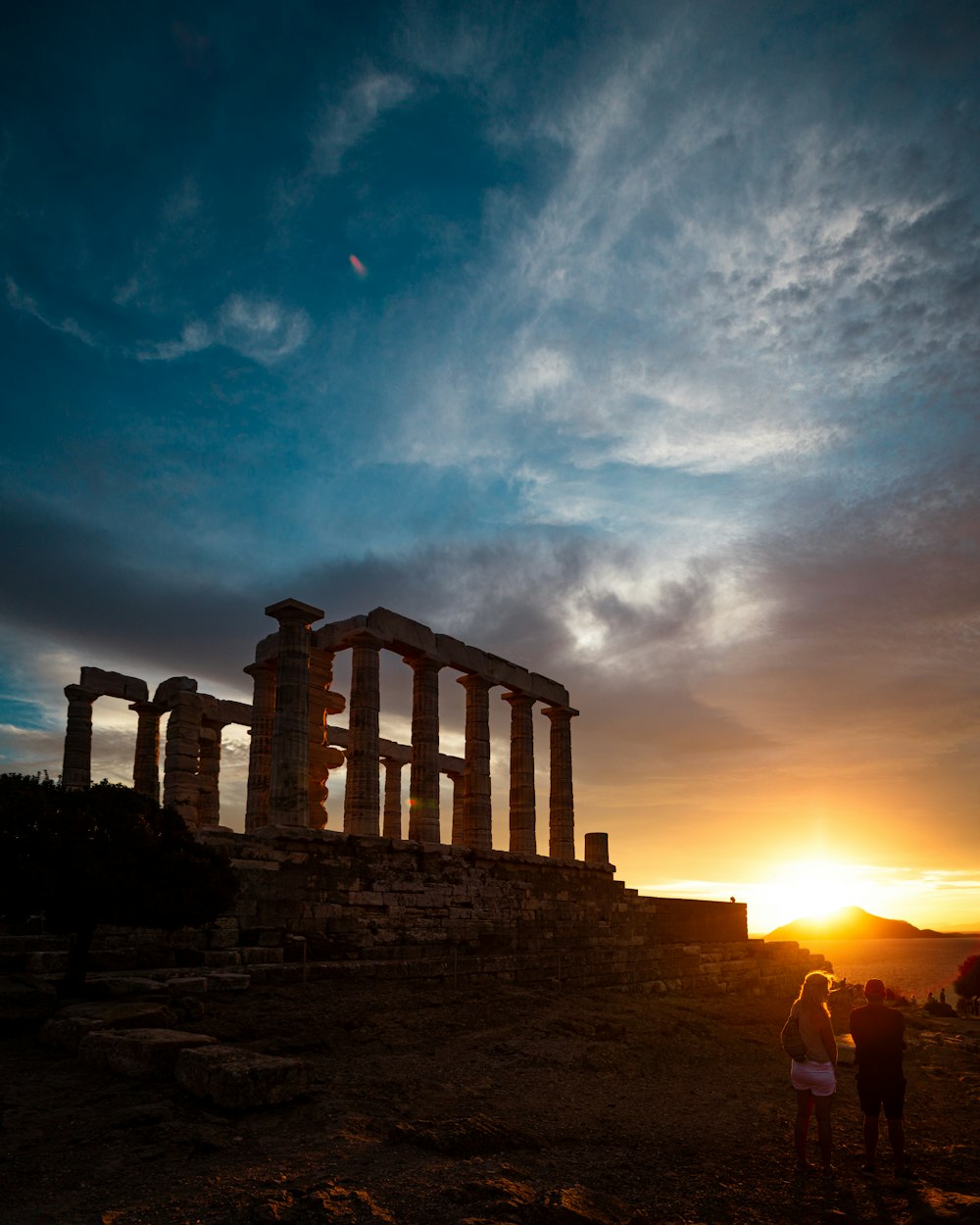 a building with columns and a sunset