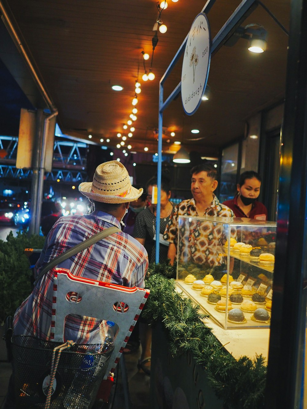 a person in a hat standing next to a display of food