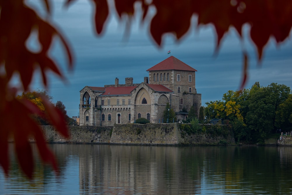 a castle on a hill by a lake