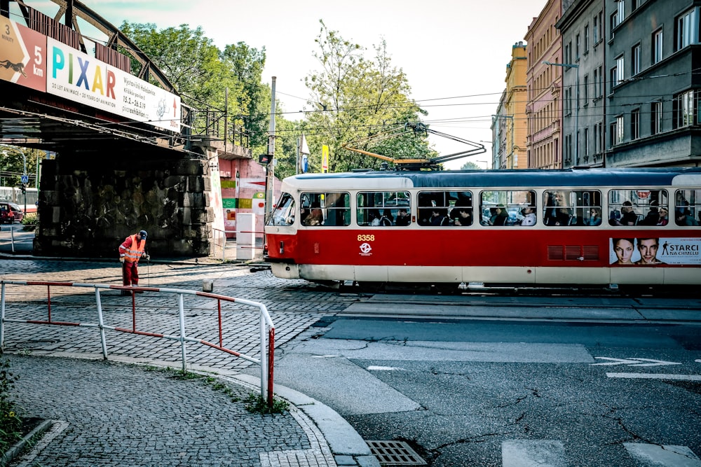 a red and white trolley on a street