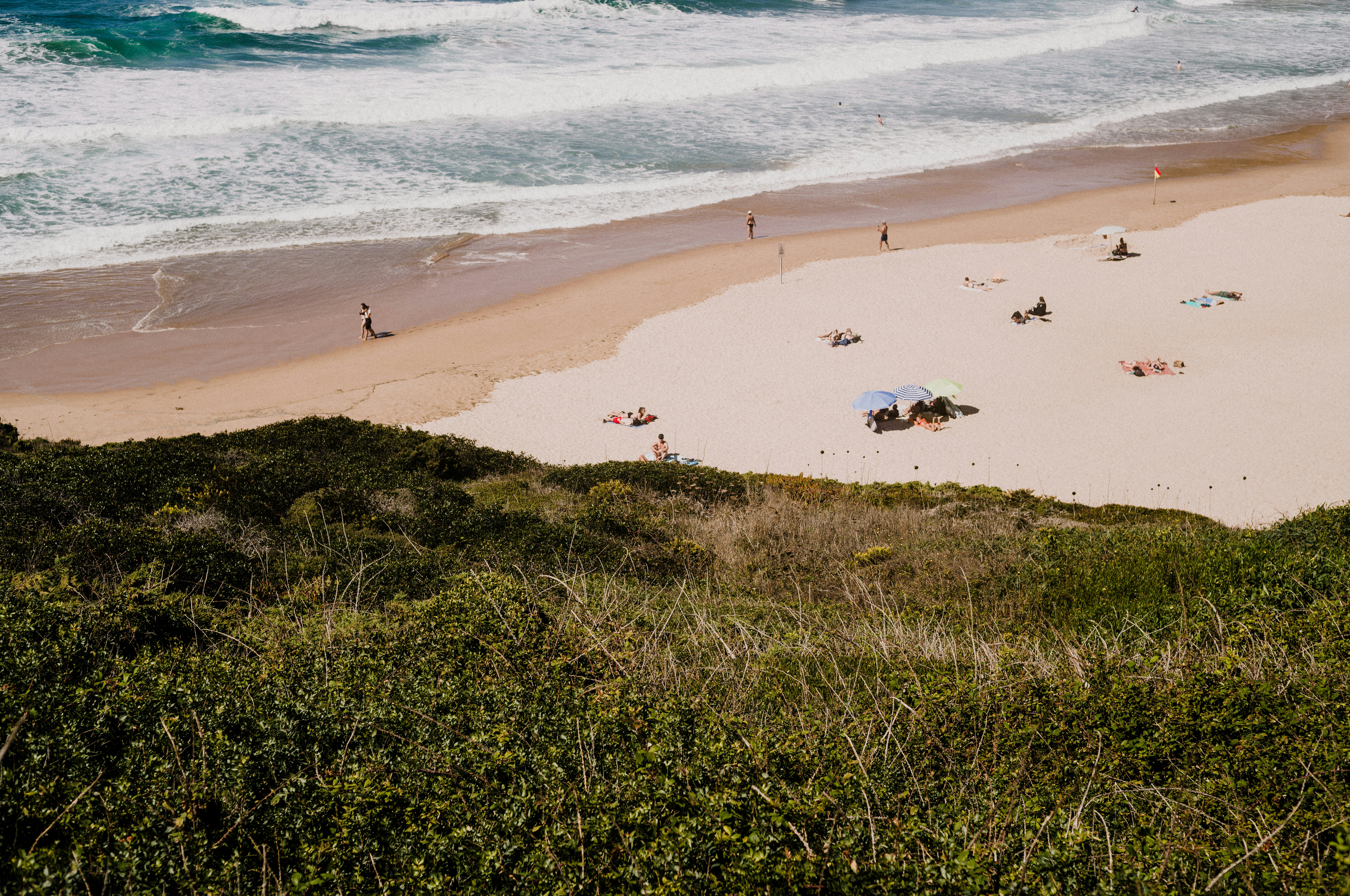 Una playa con gente y sombrillas