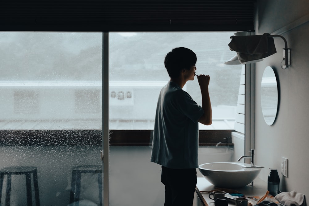 a man holding a bucket in a bathroom