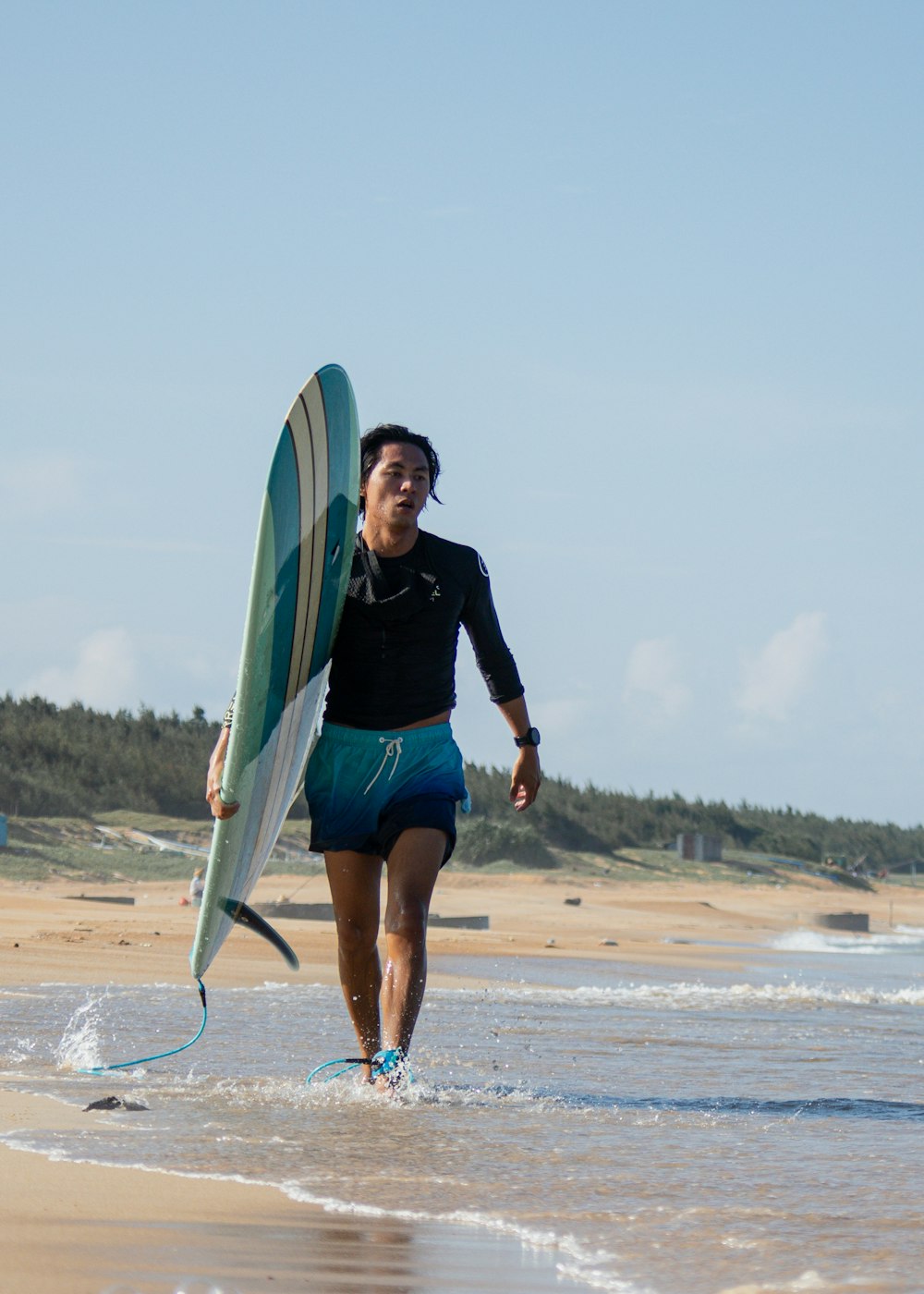 a person holding a surfboard on the beach