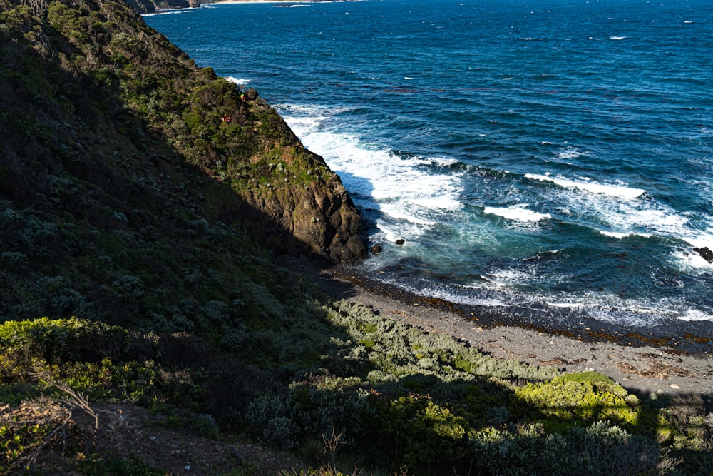 a rocky beach with a body of water in the background