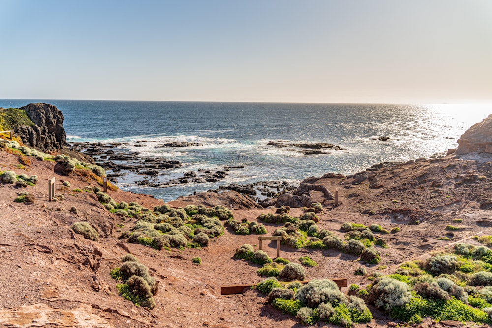 a rocky beach with a body of water in the background