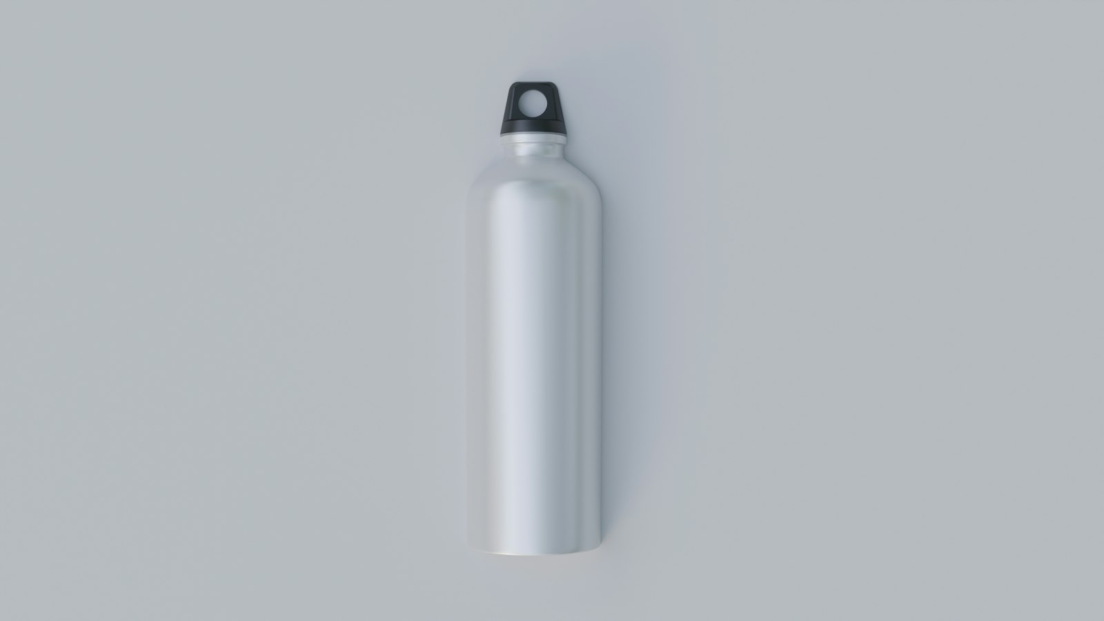 Une gourde en aluminium brossé à bouchon noir, sur fond gris