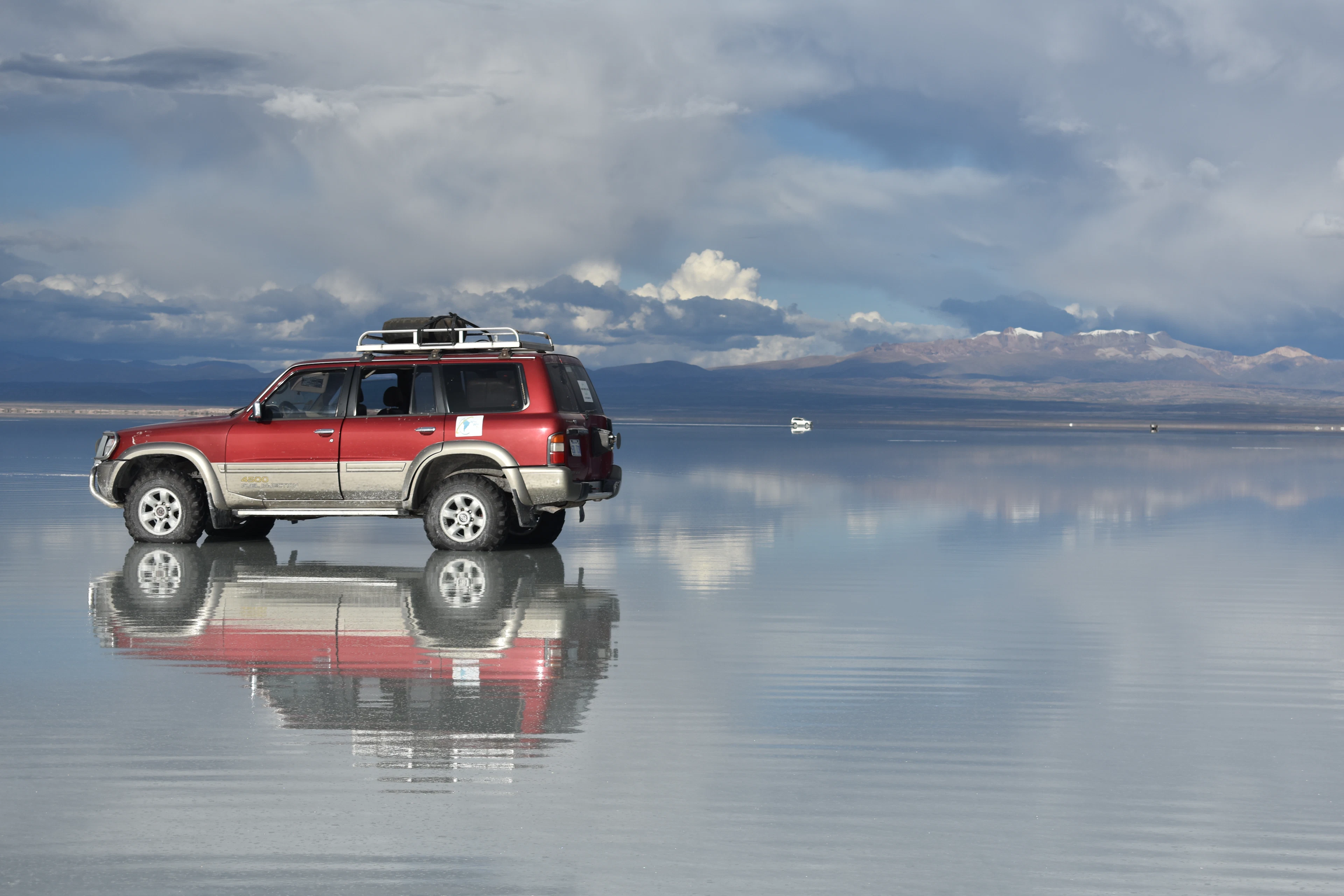 A 4×4 reflected in the water-covered Salar de Uyuni, Bolivia