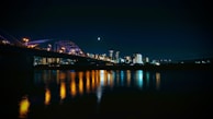 a bridge over water with a city in the background