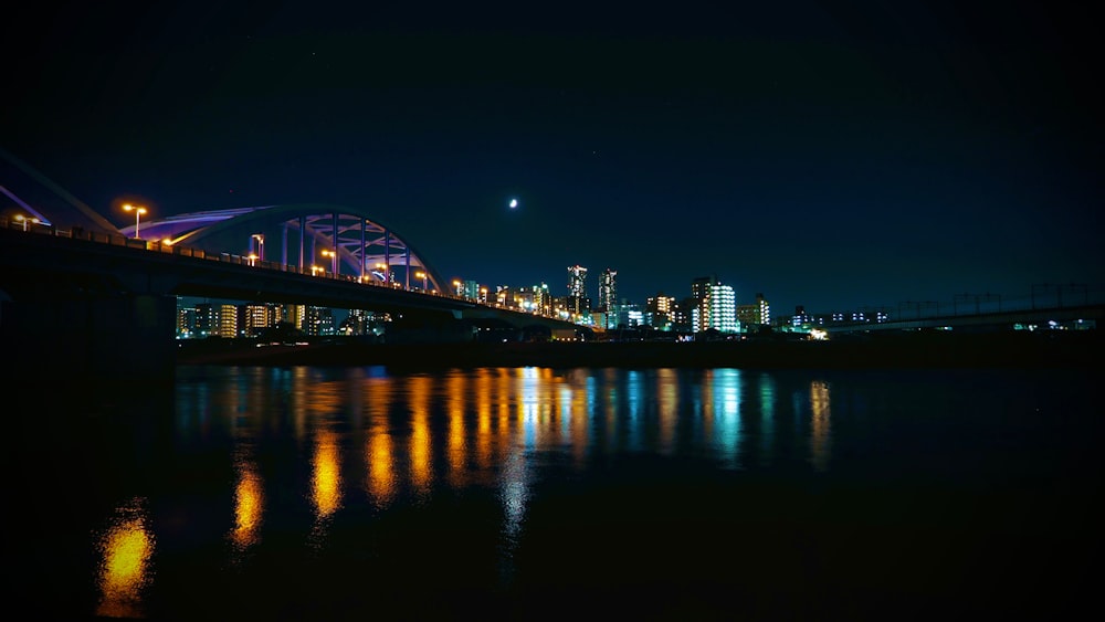 a bridge over water with a city in the background