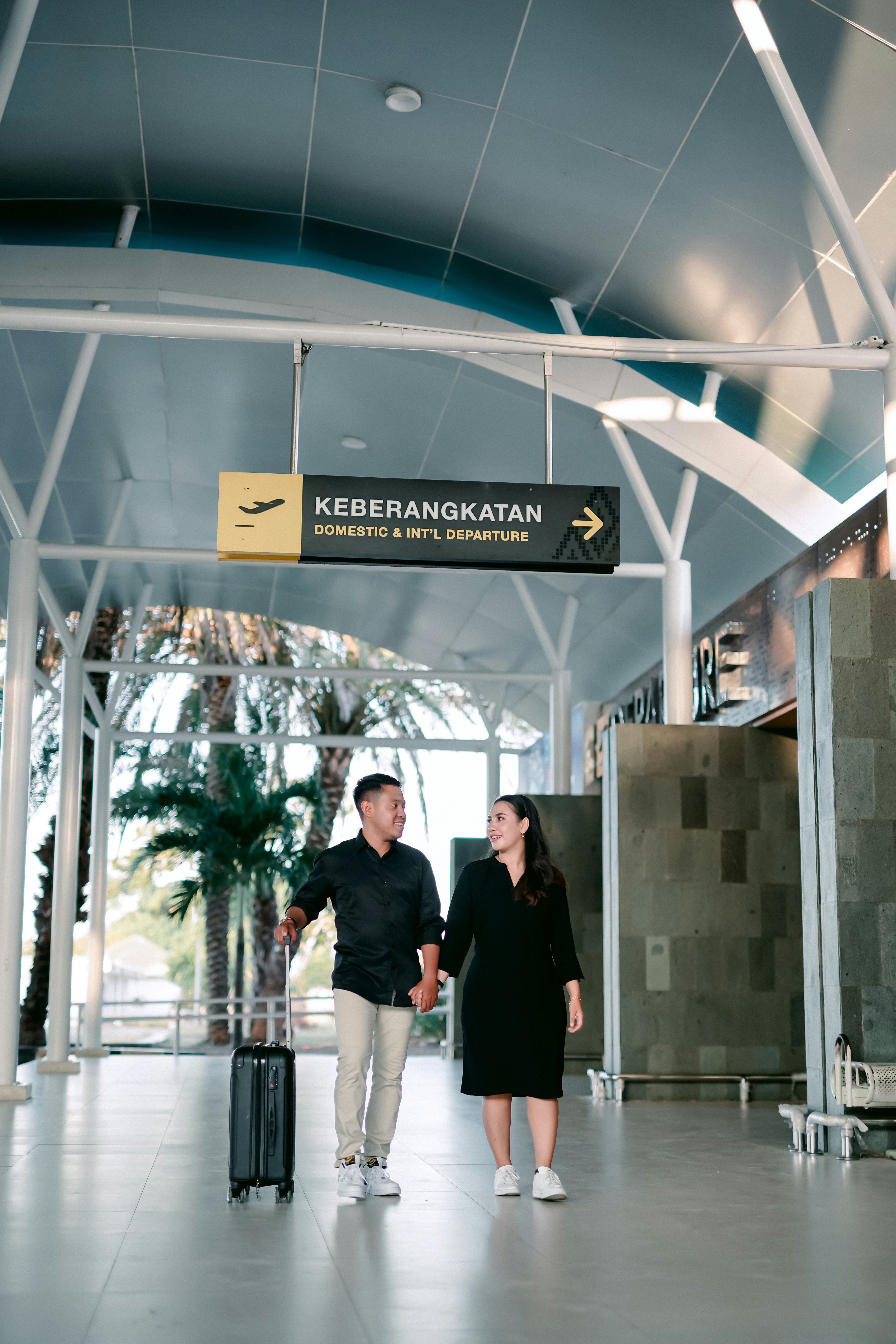 a man and woman walking in an airport