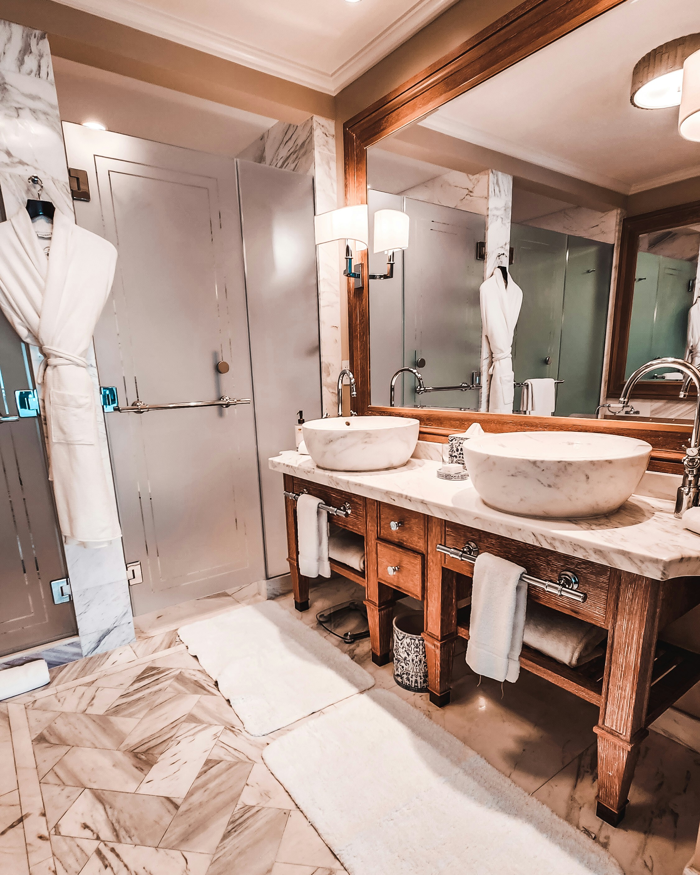 Elegant luxury spa interior with dark marble floors, low ambient lighting, and plush white robes on dark furnishings