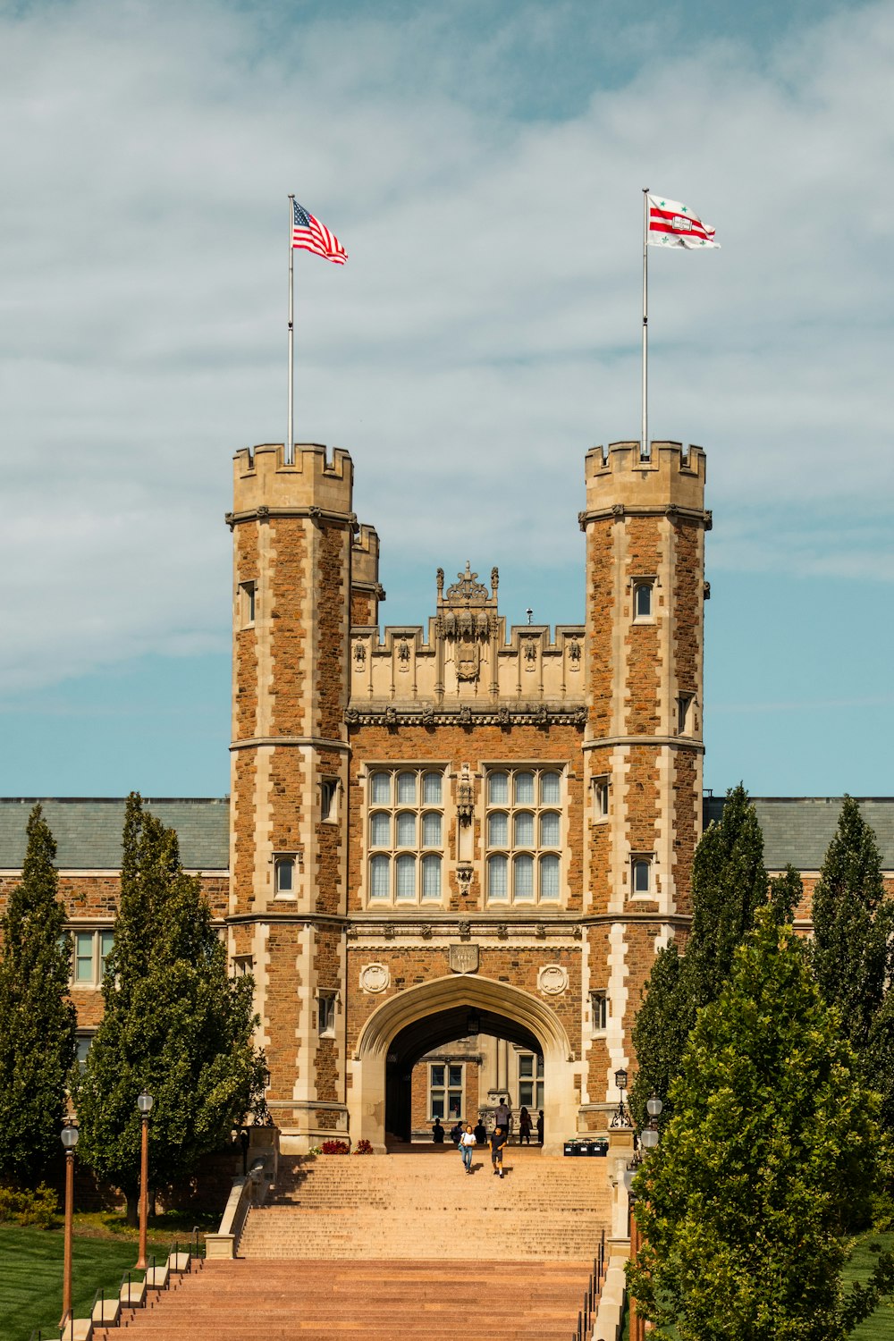 a stone building with a flag on top with Belvoir Castle in the background