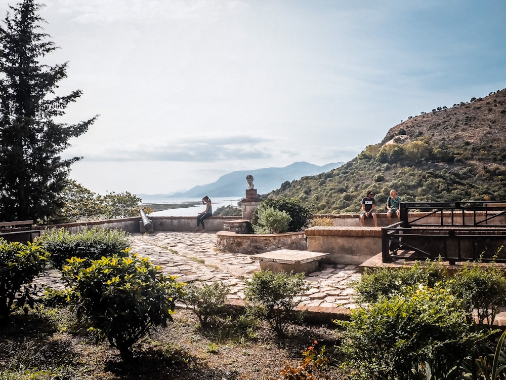 a group of people on a stone staircase with a statue in the background