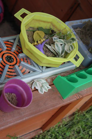 A bin filled with kinetic sand and foam shapes, perfect for tactile learning.