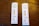 Two COVID-19 antigen rapid test kits are placed on a wooden surface. Each kit displays two lines on the result window indicating positive results. The tests are labeled with 'Rapid Response' along with 'COVID-19 Antigen' and show that results are available in 15 minutes.