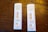 Two COVID-19 antigen rapid test kits are placed on a wooden surface. Each kit displays two lines on the result window indicating positive results. The tests are labeled with 'Rapid Response' along with 'COVID-19 Antigen' and show that results are available in 15 minutes.