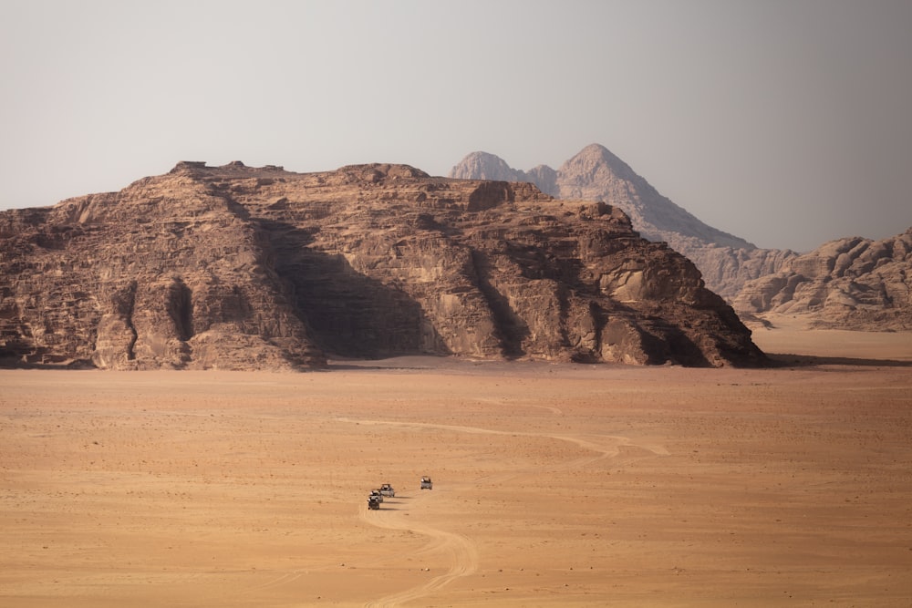a desert landscape with a few people riding motorcycles