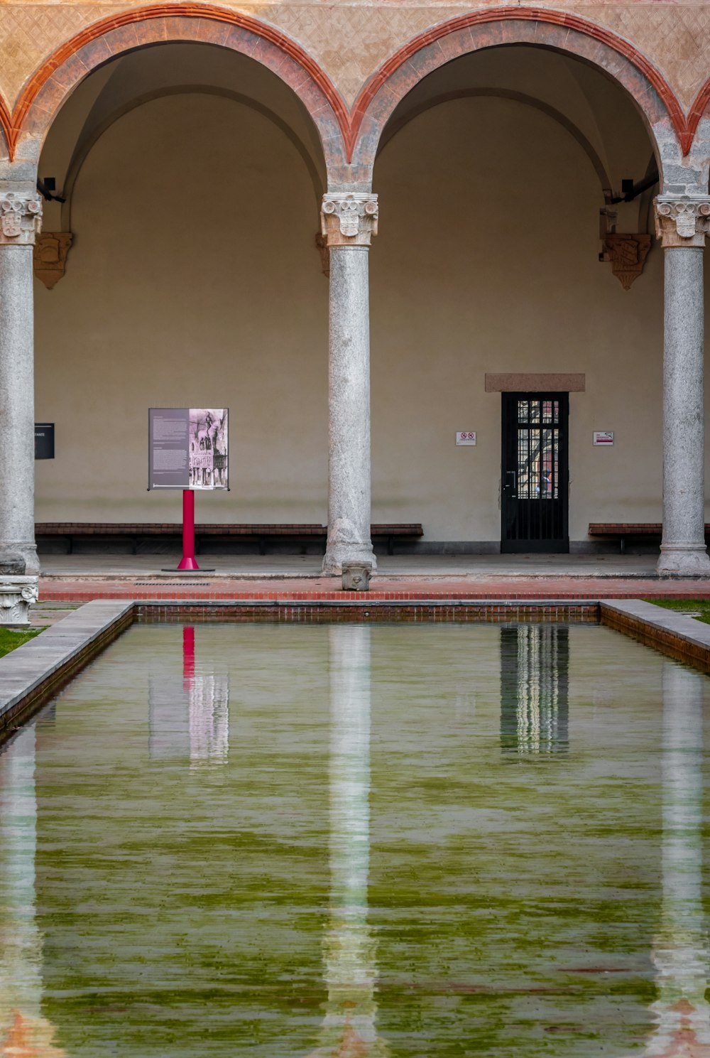 a large building with a pool of water in the front