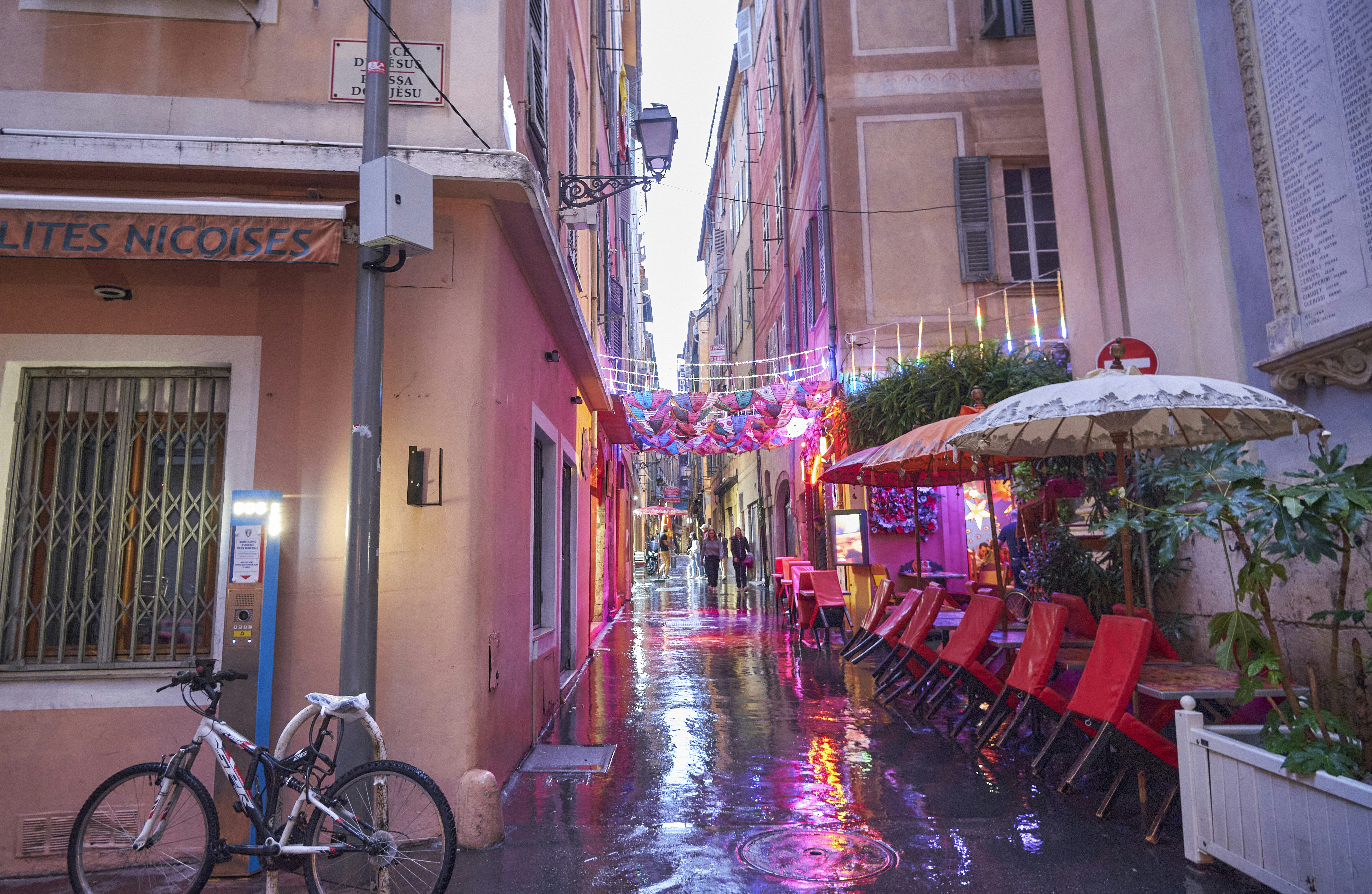 Une rue humide avec des tables et des chaises