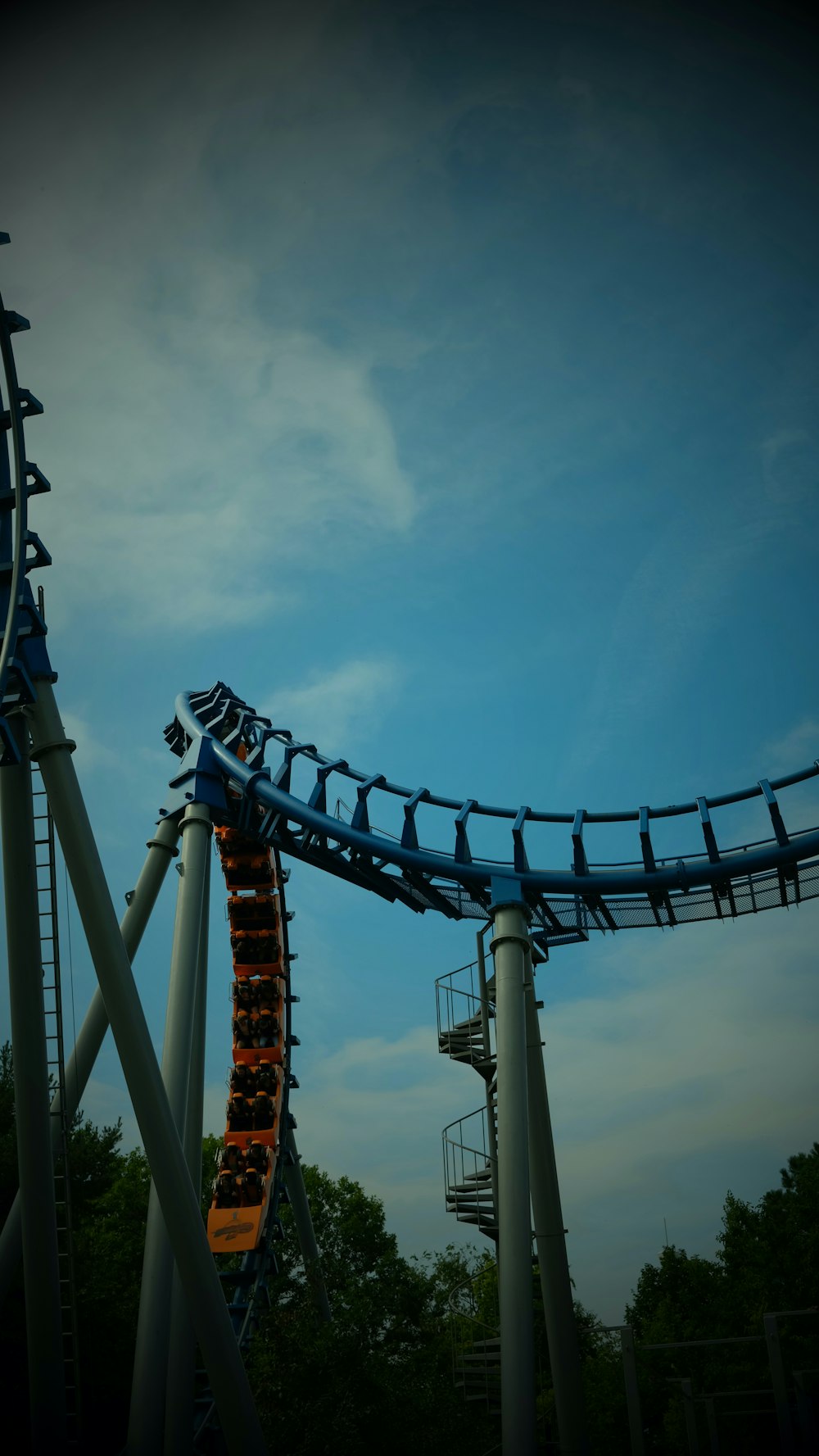a roller coaster with trees and blue sky