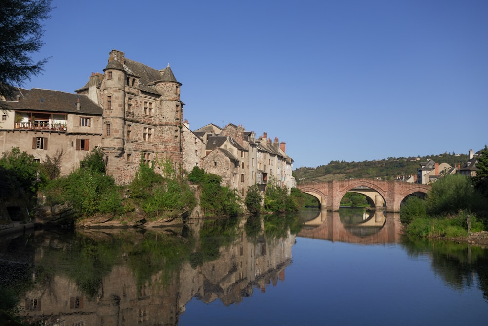 a bridge over a river leading to a large building with a bridge