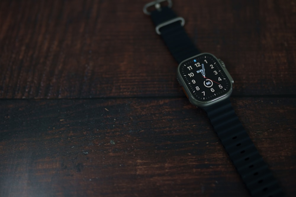 a black watch on a wooden surface