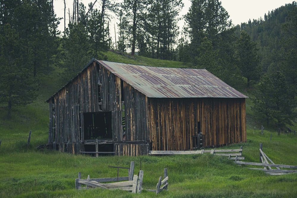 a wooden building in a field