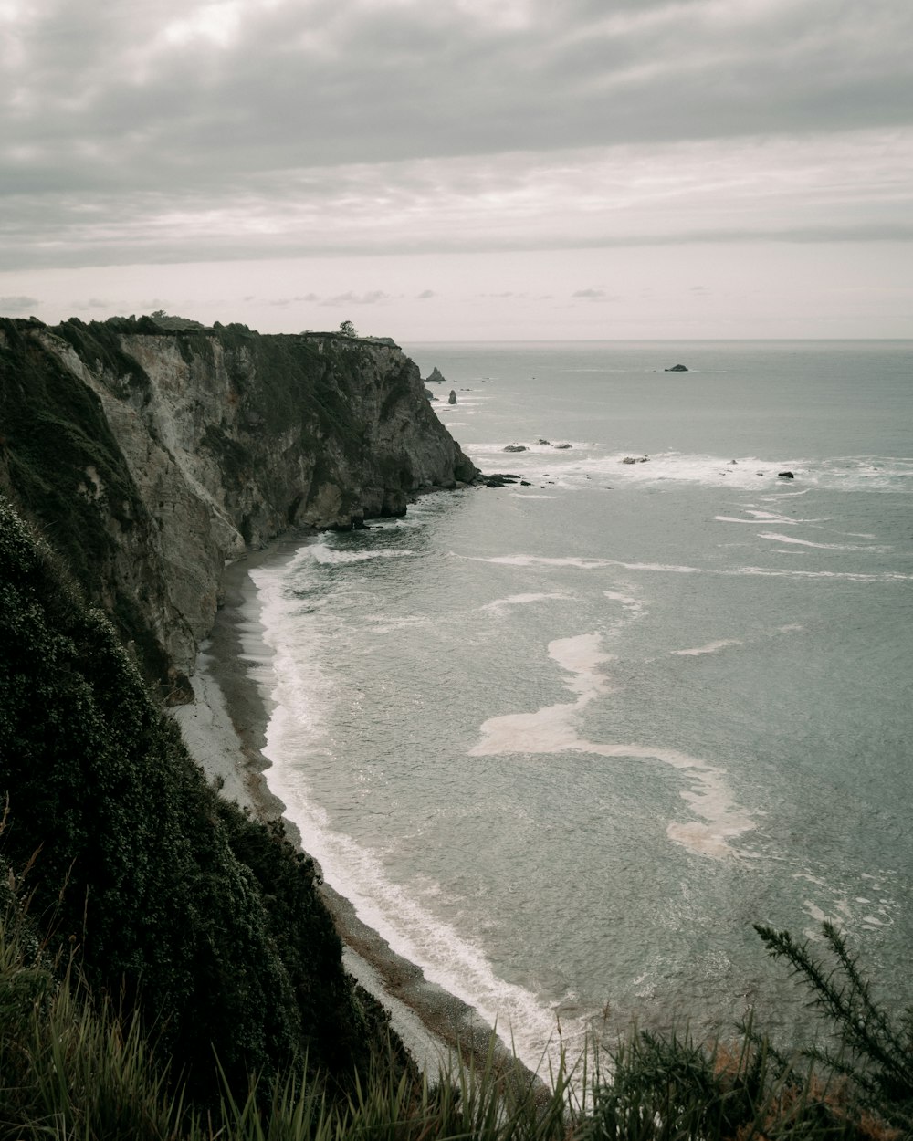 a beach with a cliff and water