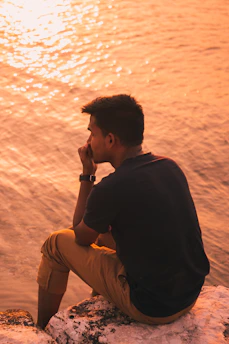 A thoughtful person reflecting outdoors during a peaceful sunset.