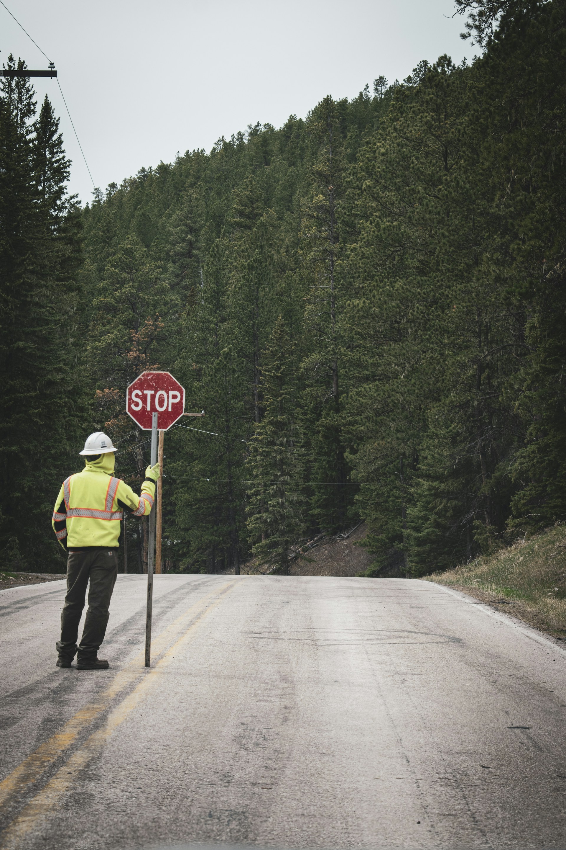 a person stands next to a stop sign