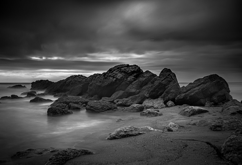 a rocky beach with a cloudy sky