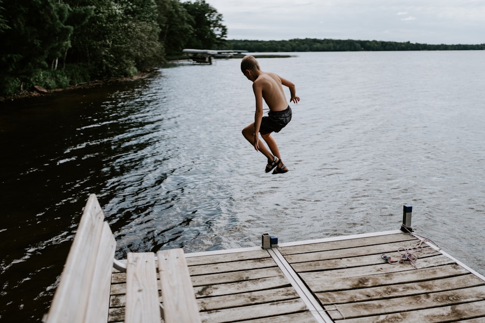 a man jumping into a lake