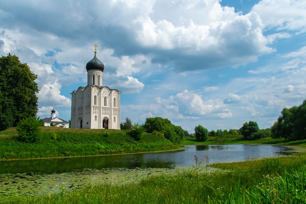 a building with a tower and a pond in front of it