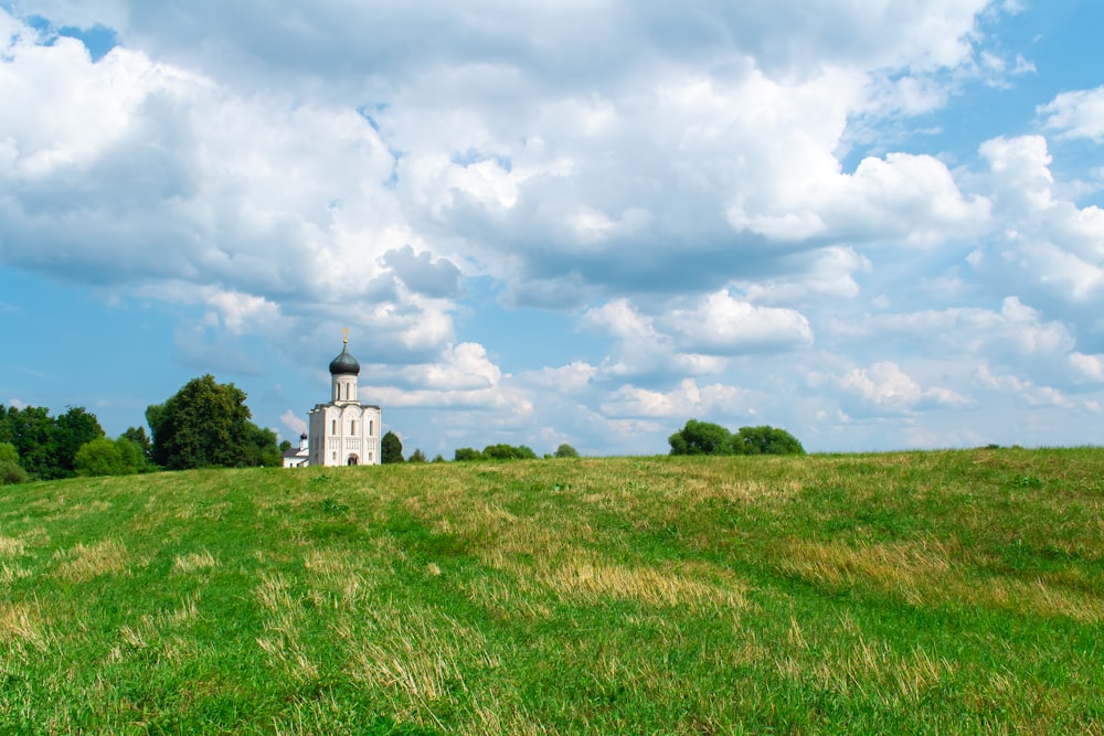 a grassy field with a building in the distance