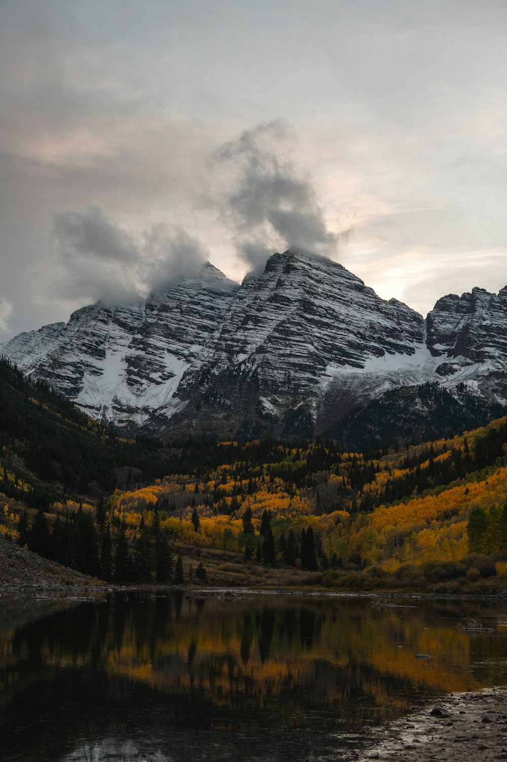 a lake with trees and mountains in the background