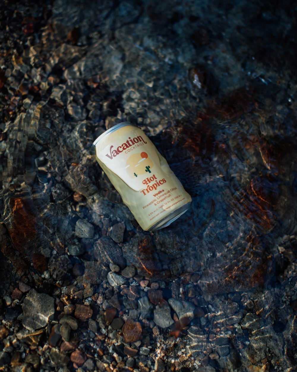 a bottle of liquid on rocks