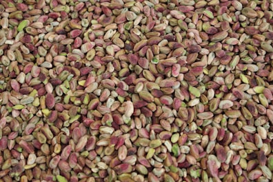 A vibrant pile of green pistachios spilling from a rustic sack.