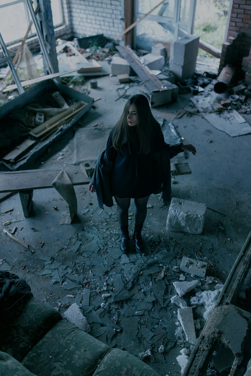 a woman standing in a rubble heap