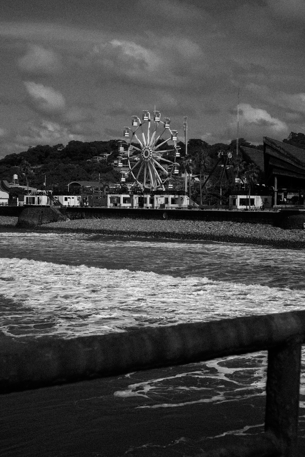 a large ferris wheel next to a body of water