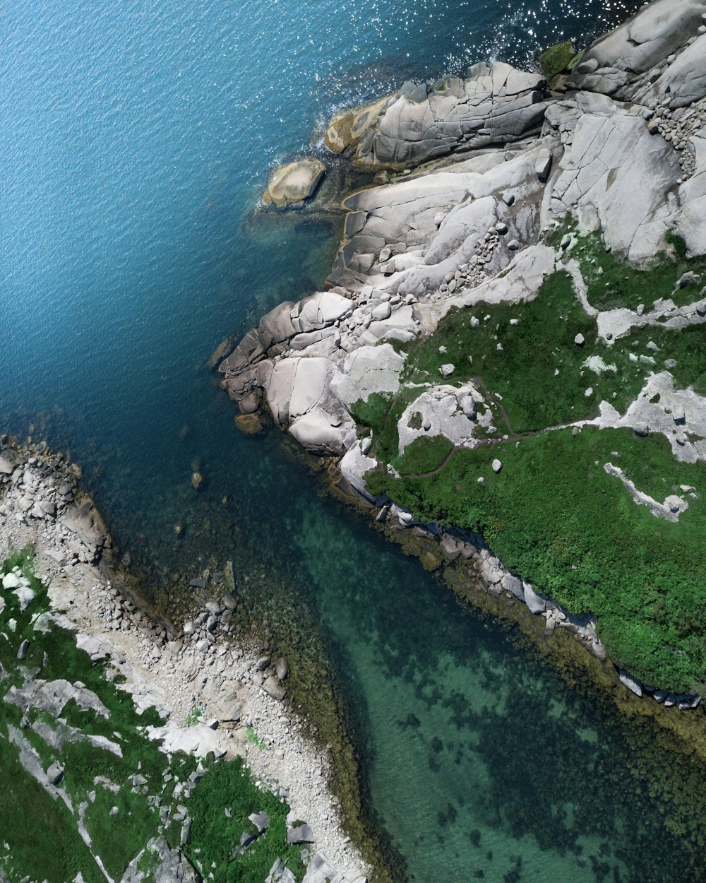 a rocky cliff with a body of water below