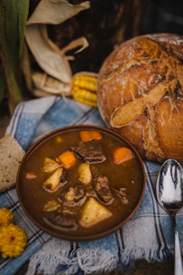 A rustic wooden table set with a steaming plate of traditional Irish stew and fresh soda bread.