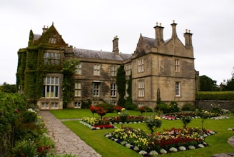 a large house with a garden in front of it with Muckross House in the background